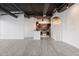 Spacious living area adjacent to a modern kitchen with hardwood-style flooring and exposed ductwork at 1 E Lexington Ave # 1302, Phoenix, AZ 85012