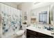 Cozy bathroom with floral-themed shower curtain and dark-wood vanity at 12172 W Davis Ln, Avondale, AZ 85323