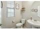 Well-lit powder room with modern fixtures, decorative mirror, and tasteful accents at 12172 W Davis Ln, Avondale, AZ 85323
