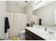 Well-lit bathroom with a floral shower curtain and spacious countertop at 12172 W Davis Ln, Avondale, AZ 85323