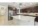Gourmet kitchen features stainless steel appliances, dark cabinets, and a large quartz island with pendant lighting at 12172 W Davis Ln, Avondale, AZ 85323