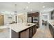 The gourmet kitchen features a large center island with stainless steel appliances and dark wood cabinetry at 12172 W Davis Ln, Avondale, AZ 85323