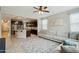 Inviting living room with plush sofa, decorative rug, ceiling fan, and seamless flow to the kitchen at 12172 W Davis Ln, Avondale, AZ 85323