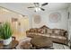 Comfortable living room showcasing a ceiling fan, a ornate sofa and a decorative rug over the tile floor at 12172 W Davis Ln, Avondale, AZ 85323