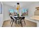 Bright dining area featuring a round table, modern lighting, and large windows for ample natural light at 12469 W Hearn Rd, El Mirage, AZ 85335