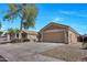 Single-story home with neutral exterior, two-car garage, tidy landscaping and spacious driveway at 12469 W Hearn Rd, El Mirage, AZ 85335