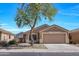 Charming single-story home featuring a well-manicured front yard and an attached two-car garage at 12469 W Hearn Rd, El Mirage, AZ 85335