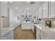 Bright kitchen features white cabinetry, quartz countertops, stainless appliances, and views to dining area at 12469 W Hearn Rd, El Mirage, AZ 85335