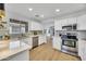 Modern kitchen featuring stainless steel appliances, white cabinets, and hardwood flooring at 12469 W Hearn Rd, El Mirage, AZ 85335