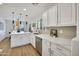 Bright kitchen features white cabinetry, quartz countertops, stainless appliances, and views to dining area at 12469 W Hearn Rd, El Mirage, AZ 85335