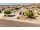 Elevated view of a desert home highlighting its tile roof, xeriscaped yard, and convenient three-car garage at 13806 W Remuda Dr, Peoria, AZ 85383