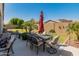 Backyard with an outdoor dining set and an umbrella for shade, plus manicured landscaping at 13806 W Remuda Dr, Peoria, AZ 85383