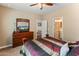 Comfortable bedroom featuring a ceiling fan and wooden dresser with attached mirror and television at 13806 W Remuda Dr, Peoria, AZ 85383
