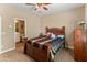 Bedroom featuring a wooden bed frame, carpet flooring, and a view to the connected bathroom at 13806 W Remuda Dr, Peoria, AZ 85383