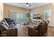 Cozy living room with a ceiling fan, tile floors, an entertainment center, and comfortable reclining furniture at 13806 W Remuda Dr, Peoria, AZ 85383
