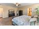 Spacious main bedroom with a ceiling fan, dark wood furnishings and a TV with fireplace at 13806 W Remuda Dr, Peoria, AZ 85383