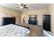 Comfortable main bedroom featuring a ceiling fan, a fireplace, and ample furniture at 13806 W Remuda Dr, Peoria, AZ 85383