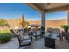 Inviting covered patio with comfortable seating, a dining table, and a relaxing hot tub for outdoor entertaining at 13806 W Remuda Dr, Peoria, AZ 85383
