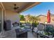 Inviting covered patio with ceiling fan, outdoor furniture, and views of the landscaped backyard at 13806 W Remuda Dr, Peoria, AZ 85383