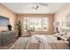 Serene bedroom featuring a bay window with plantation shutters, ceiling fan and stylish decor at 14154 W Yosemite Dr, Sun City West, AZ 85375