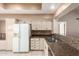 A full view of the kitchen featuring granite countertops, neutral walls, and modern appliances at 14154 W Yosemite Dr, Sun City West, AZ 85375