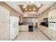 Bright kitchen featuring cream-colored cabinets, granite countertops, and modern appliances at 14154 W Yosemite Dr, Sun City West, AZ 85375