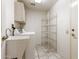 Convenient laundry room with washer, dryer, utility sink, storage shelves, and tile flooring at 14154 W Yosemite Dr, Sun City West, AZ 85375