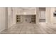 Open living area with tile floors and view of the built-in shelving unit and kitchen at 14154 W Yosemite Dr, Sun City West, AZ 85375