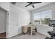 Bright bedroom features an exercise bike, a modern ceiling fan and a desk near the window at 1482 W Gloucester W Rd, San Tan Valley, AZ 85143