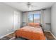 Cozy bedroom with wood-look floors, ceiling fan, blind-covered window, and decorative shelves at 1518 W Crape Rd, San Tan Valley, AZ 85140