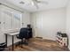 Functional bedroom with wood-look floors, ceiling fan, desk, and good natural light at 1518 W Crape Rd, San Tan Valley, AZ 85140