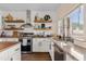 Kitchen with white cabinetry, stainless steel appliances, tile backsplash, granite countertops, and butcher block island at 1518 W Crape Rd, San Tan Valley, AZ 85140