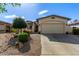 Charming home with a two-car garage, well-manicured yard, and appealing desert landscaping at 15246 N 138Th Ln, Surprise, AZ 85379