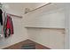 Spacious walk-in closet features ample shelving and wooden rod racks for optimal storage at 15246 N 138Th Ln, Surprise, AZ 85379