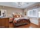 Comfortable bedroom with hardwood floors, ceiling fan and a large bed with decorative pillows at 16450 E Avenue Of The Fountain -- # 47, Fountain Hills, AZ 85268