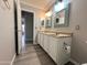 Well-lit bathroom with a double sink vanity, framed mirrors, and modern fixtures at 1704 E Redfield Rd, Gilbert, AZ 85234
