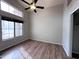 Bedroom featuring wood-look floors, a ceiling fan, and a large window letting in natural light at 1704 E Redfield Rd, Gilbert, AZ 85234