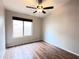 Empty bedroom featuring wood-look floors, one window and ceiling fan at 1704 E Redfield Rd, Gilbert, AZ 85234