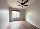Empty bedroom featuring wood-look floors, one window and ceiling fan at 1704 E Redfield Rd, Gilbert, AZ 85234