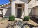 Charming front entrance with a covered porch, decorative shrubs, and a security screen door at 1704 E Redfield Rd, Gilbert, AZ 85234