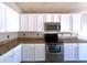 Modern kitchen featuring granite countertops, stainless steel appliances, and white cabinetry at 1704 E Redfield Rd, Gilbert, AZ 85234