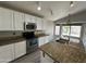 Bright kitchen featuring white cabinets, stainless steel appliances, and a granite countertop island at 1704 E Redfield Rd, Gilbert, AZ 85234