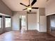 Spacious primary bedroom featuring wood-look floors, ceiling fan, and a connecting bathroom and flex space at 1704 E Redfield Rd, Gilbert, AZ 85234