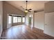 Spacious primary bedroom featuring wood-look floors, ceiling fan, and a connecting bathroom and flex space at 1704 E Redfield Rd, Gilbert, AZ 85234