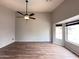 Empty primary bedroom featuring wood-look floors, ceiling fan and bay window at 1704 E Redfield Rd, Gilbert, AZ 85234