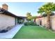 Lush backyard featuring a covered patio, artificial turf, and mature landscaping for outdoor enjoyment at 17211 N 58Th St, Scottsdale, AZ 85254