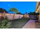 Spacious backyard with lush artificial turf, shed, string lights, and desert landscaping at 17211 N 58Th St, Scottsdale, AZ 85254