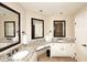 Bathroom featuring double sinks, granite countertops, neutral paint, and dark framed mirrors at 17211 N 58Th St, Scottsdale, AZ 85254