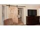 Bedroom showcasing a rustic sliding barn door leading to an ensuite bathroom at 17211 N 58Th St, Scottsdale, AZ 85254