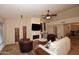 Open living room with brick fireplace, ceiling fan, travertine floors and stylish decor at 17211 N 58Th St, Scottsdale, AZ 85254